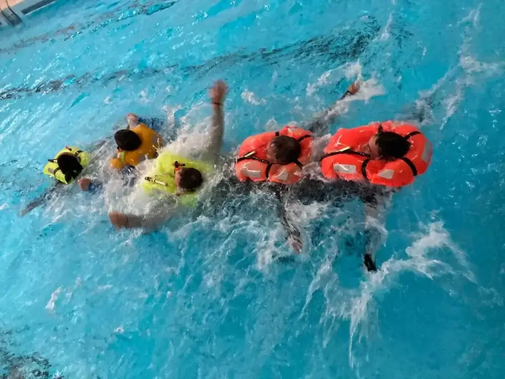 Nácvik plavání v záchranných vestách na kurzu Základy bezpečnosti na moři.